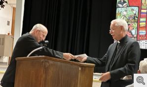 Fr. Bill presents the parish contribution to Bishop Taylor