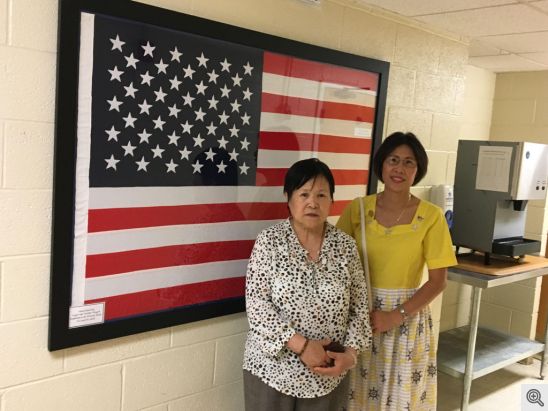 Pictured above is Vivian (on the right) and her sister, Ann standing in front of the American Flag Vivian hand sewn and presented it to the St. Francis House on June 14, 2018.